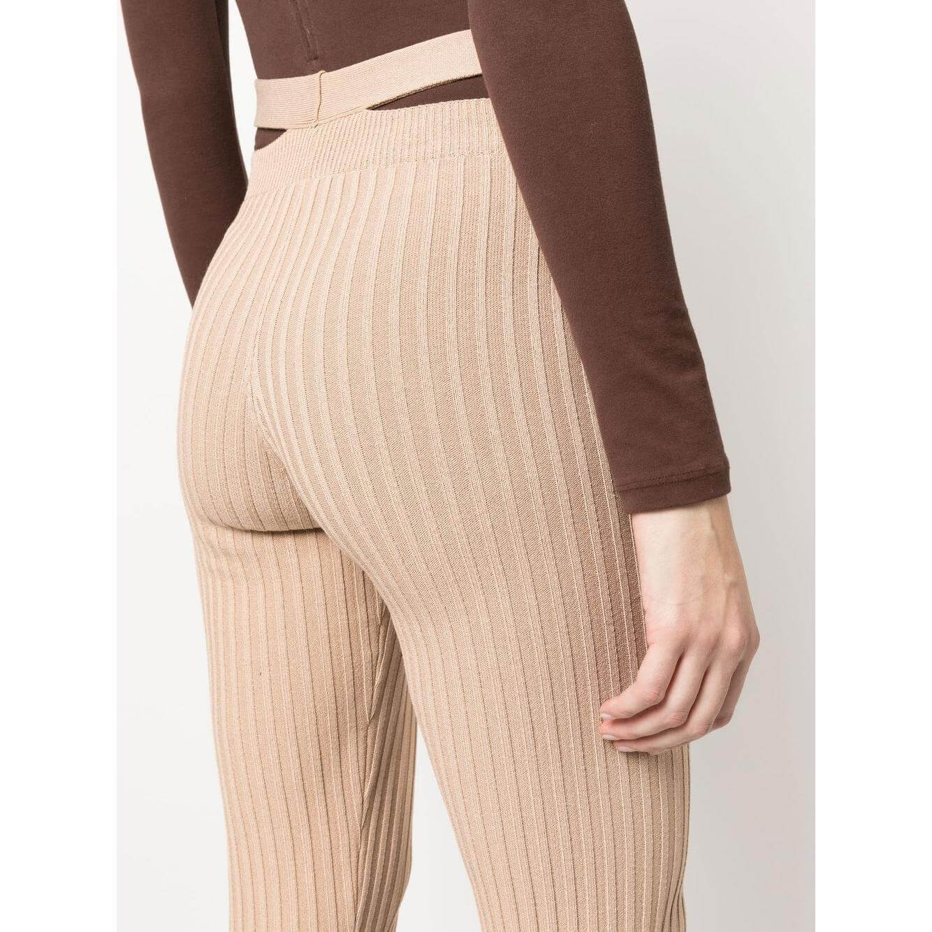 Side view of Andrea Adamo ribbed flared trousers in brown, showing high-waisted design with cut-out detailing and stretch fit.