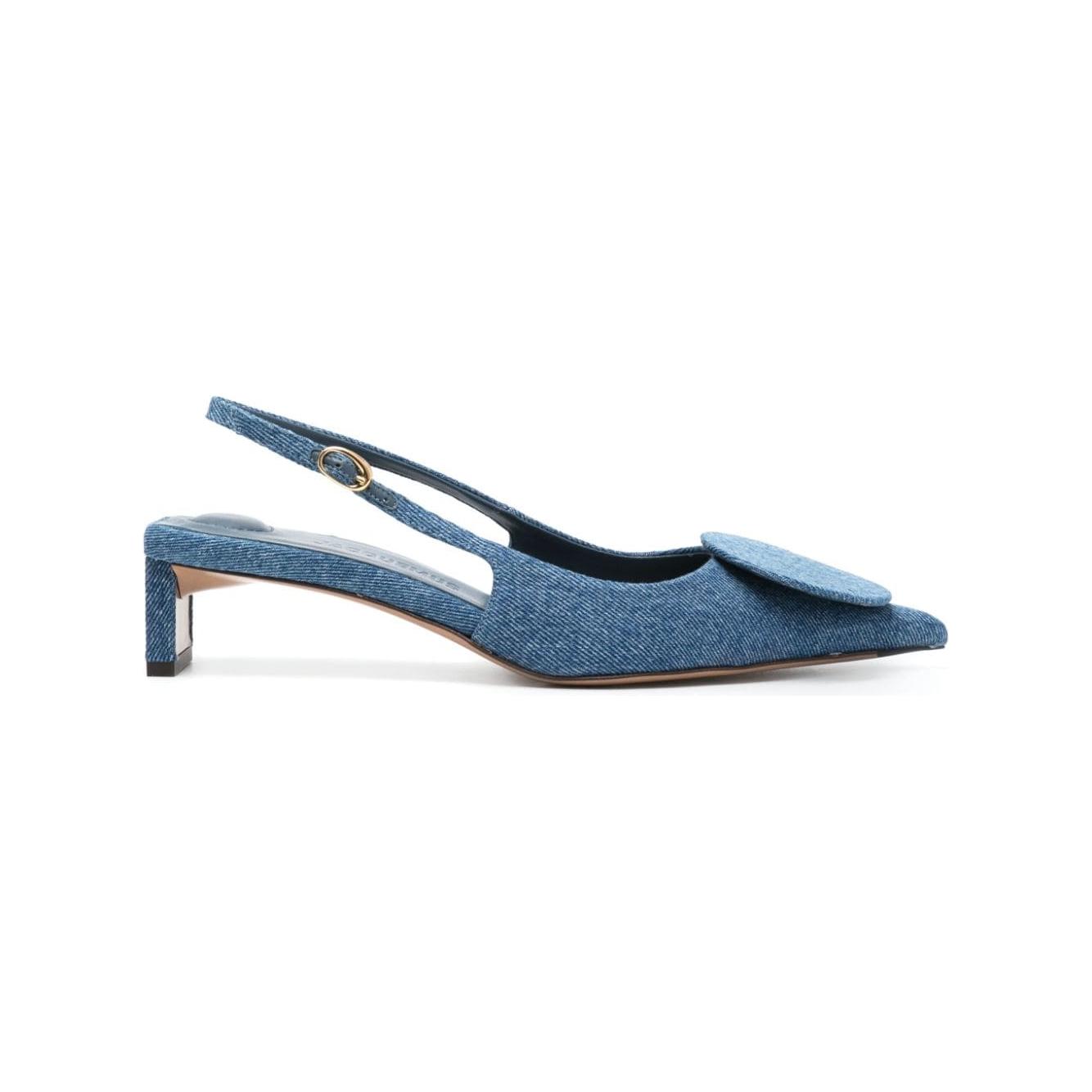 Jacquemus low Duelo slingbacks in cerulean blue denim with pointed toe, circle appliqué, and 40mm sculpted heel.