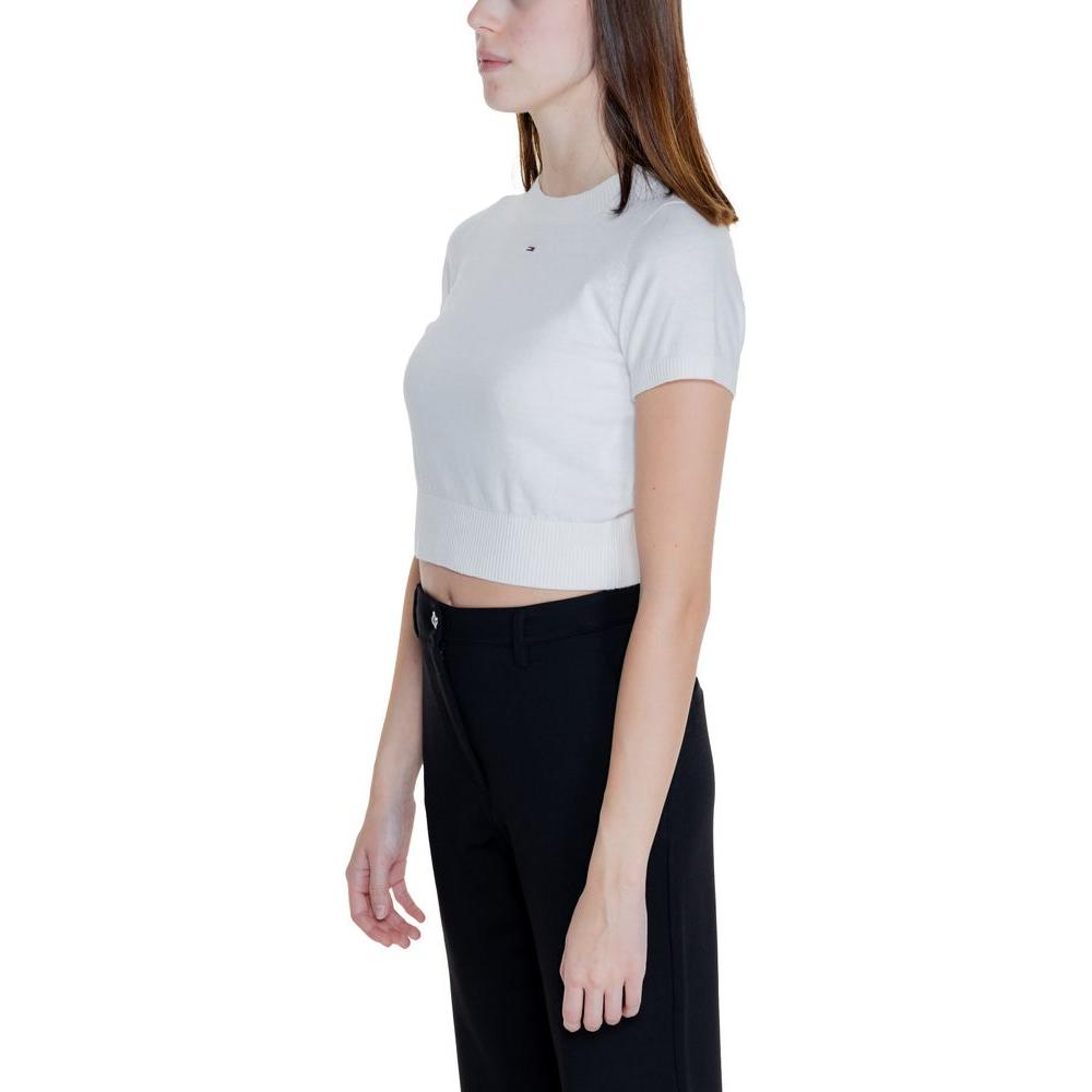 Side view of woman wearing white Tommy Hilfiger short sleeve organic cotton knit top, part of Fall/Winter collection.
