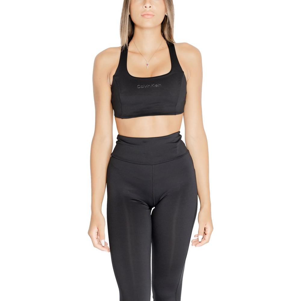 Woman wearing Calvin Klein black sports bra and leggings, made of 88% polyester and 12% elastane, offering fit and breathability for workouts.