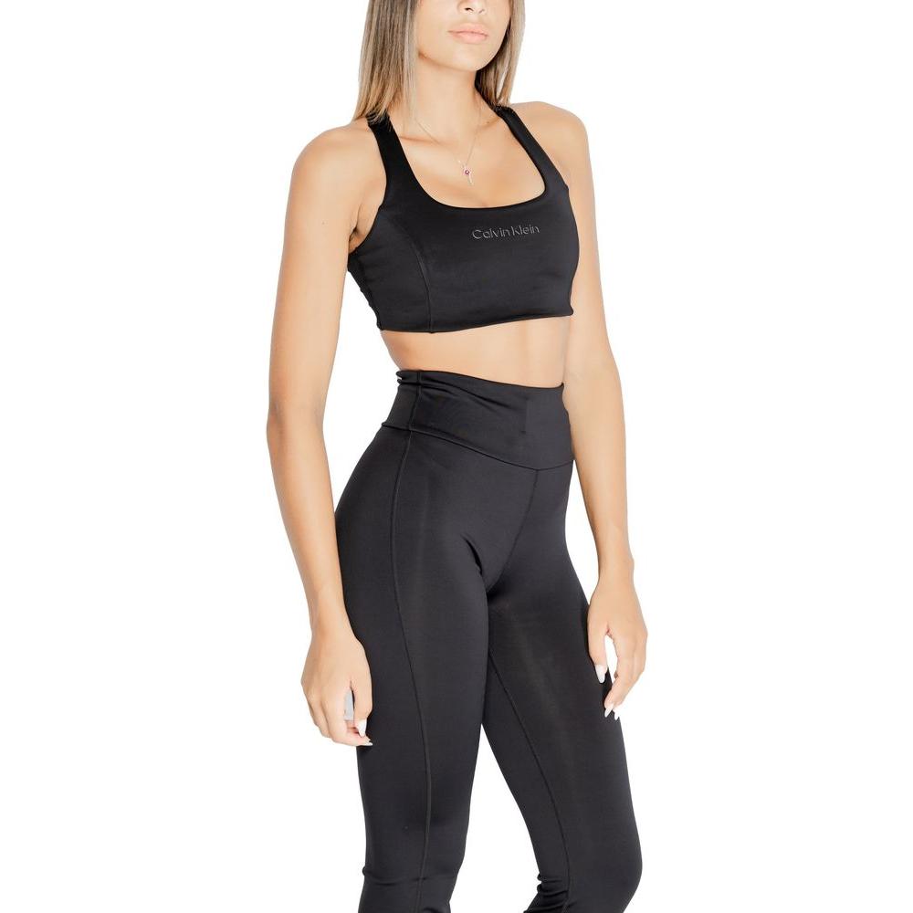 Woman wearing Calvin Klein black sports bra and leggings, showcasing modern design and fit