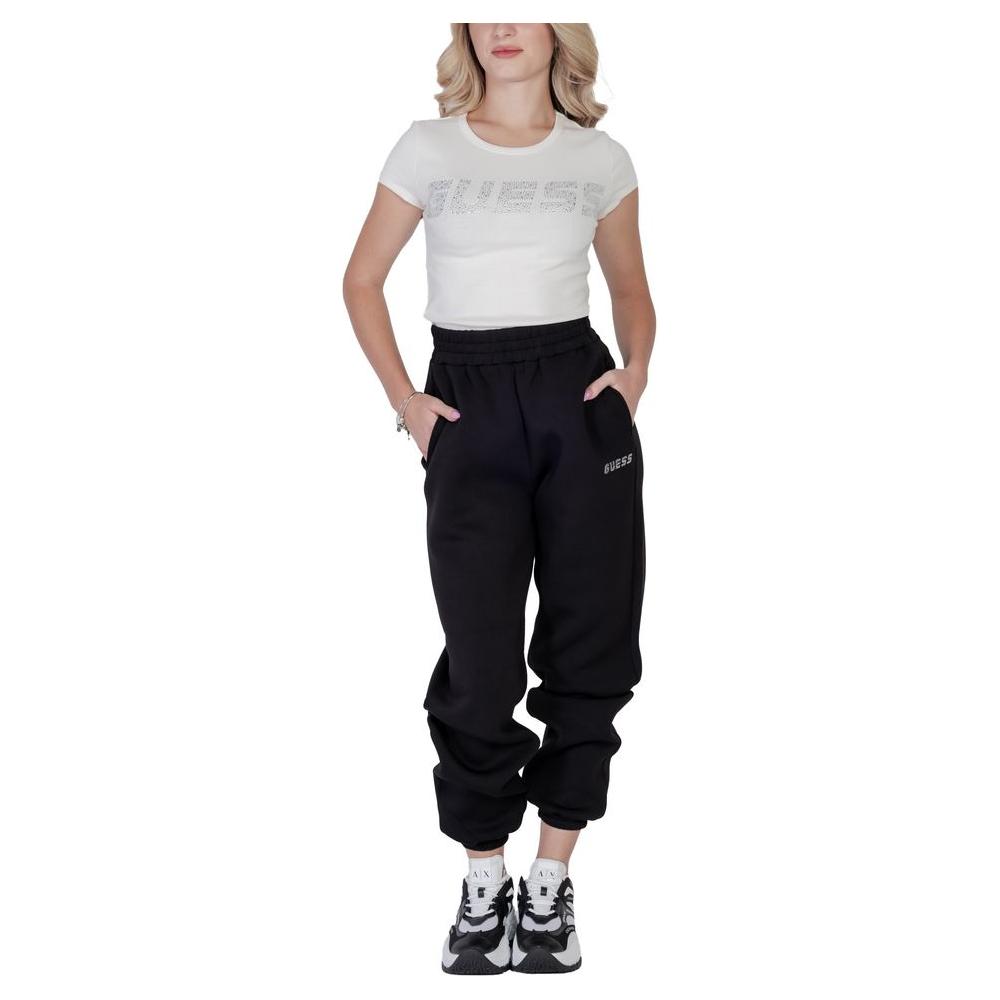Woman wearing Guess Active cream cotton t-shirt with embossed logo and black jogger pants, styled for casual activities.