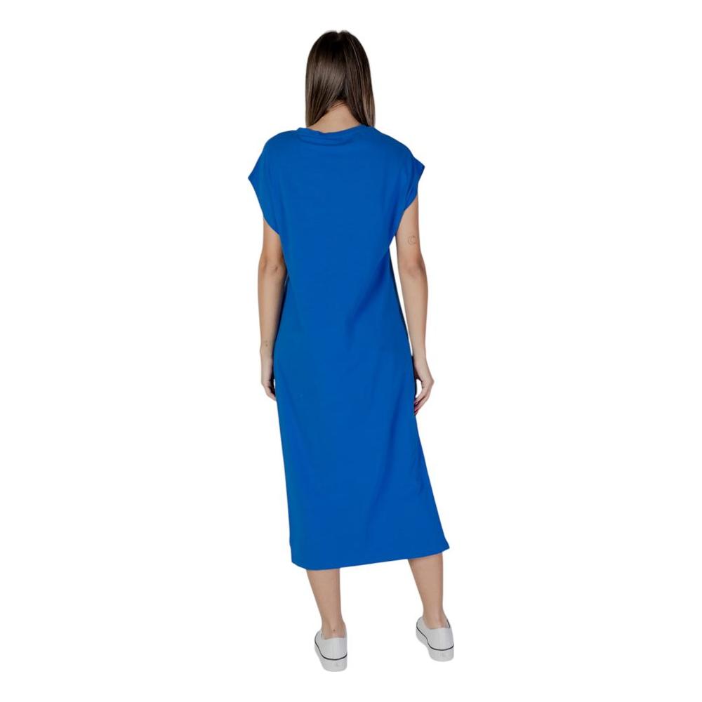 Woman wearing B.Young blue cotton dress, back view, part of spring/summer collection, made of 95% cotton and 5% elastane.