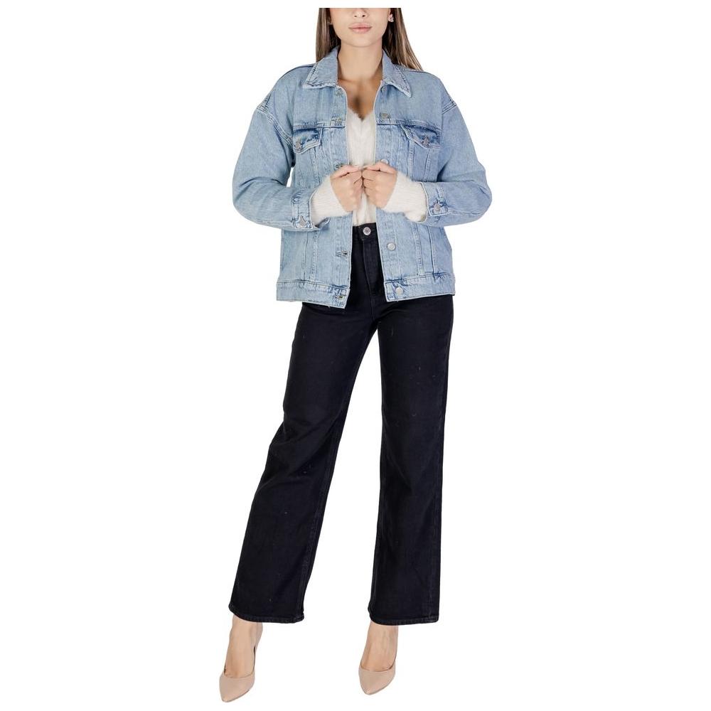 Model wearing Vero Moda light blue cotton jacket and coat, fall/winter collection, composed of cotton, polyester, recycled cotton, and elastane.