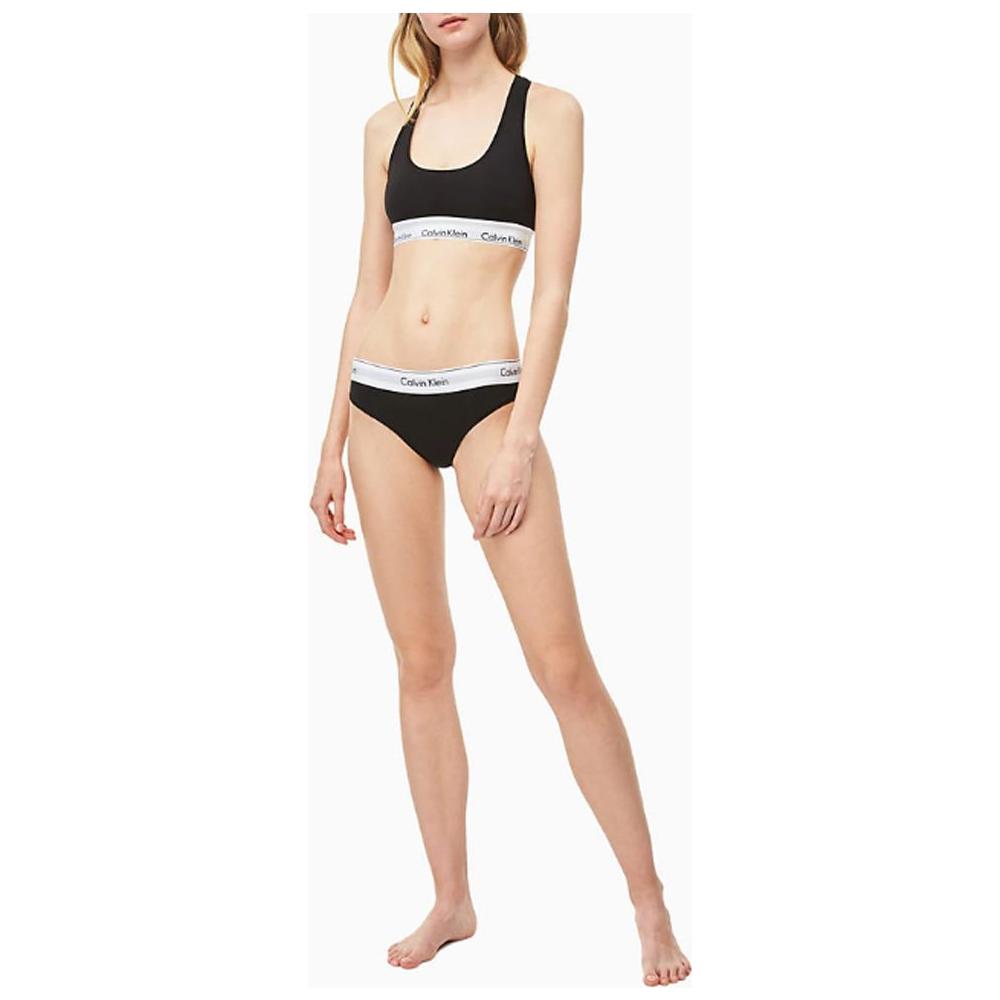 Woman wearing Calvin Klein Black Cotton Underwear set with logo waistband, showcasing a comfortable and stylish bikini design.