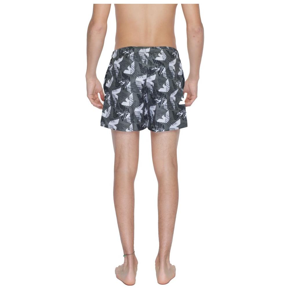 Back view of a man wearing Emporio Armani black polyester swimwear shorts with a modern design and adjustable waistband.