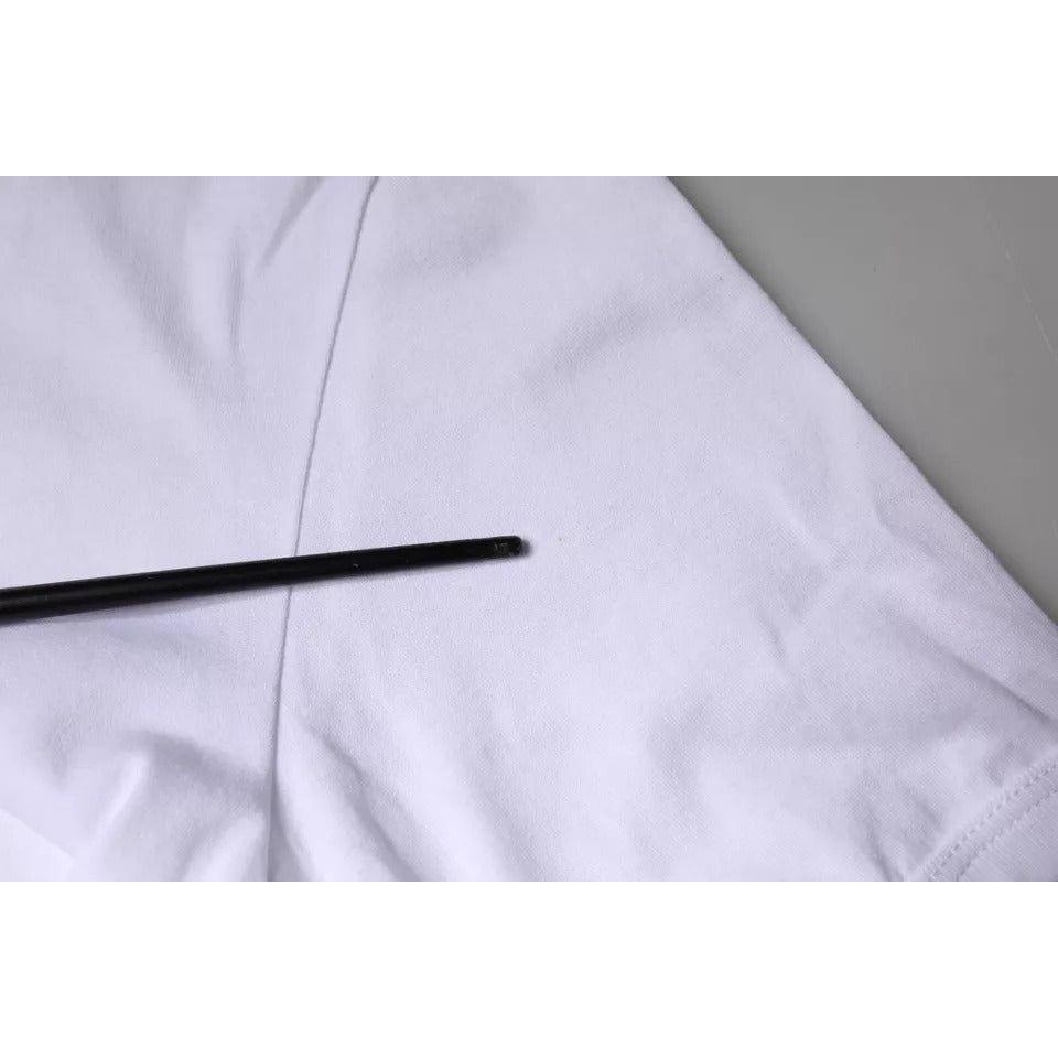 Close-up of minor stain on Dolce & Gabbana white crew neck t-shirt with DG heart embroidery, highlighted with a pointer.