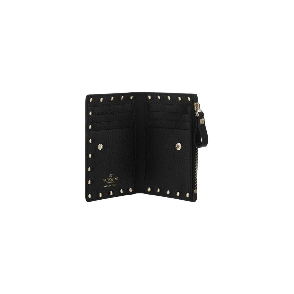 Valentino Garavani Rockstud leather card holder with studded detailing and zippered pocket, open to show interior card slots.