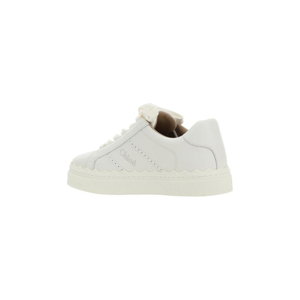 Side view of white Chloé Lauren calfskin sneakers with lace-up front, round toe, flat sole, perforated sides, and iconic brand monogram.