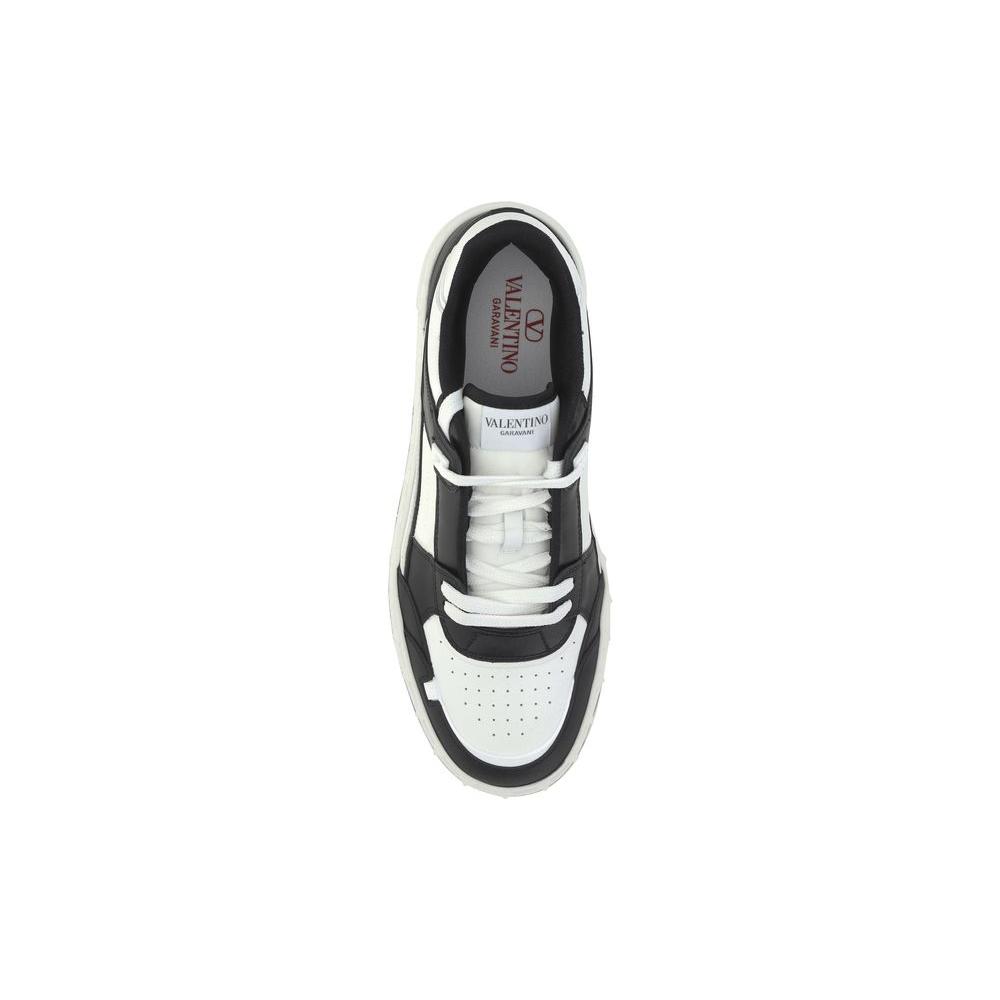 Top view of Valentino Garavani leather sneaker with laces, flat sole, contrast stitching, and logo embroidery on front tab.