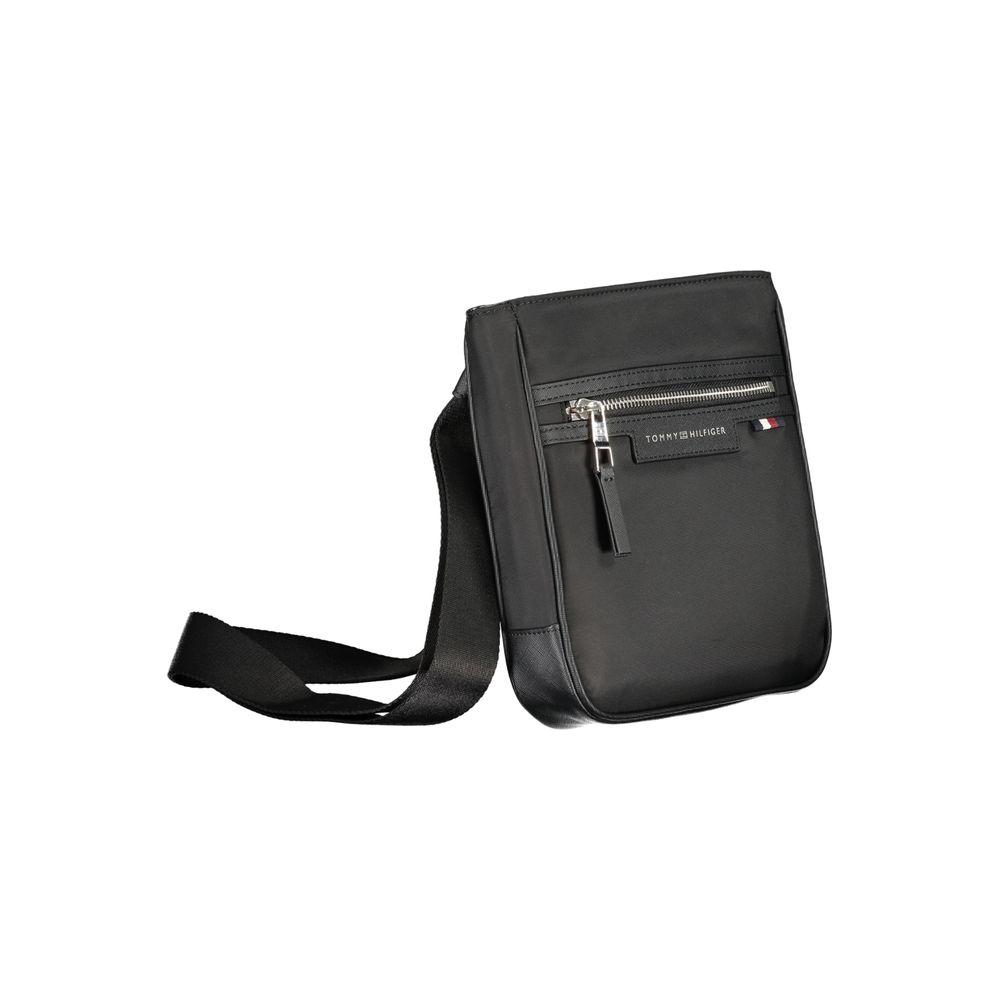 Tommy Hilfiger black polyester shoulder bag with adjustable strap, external and internal pockets, zip closure, and logo detail.