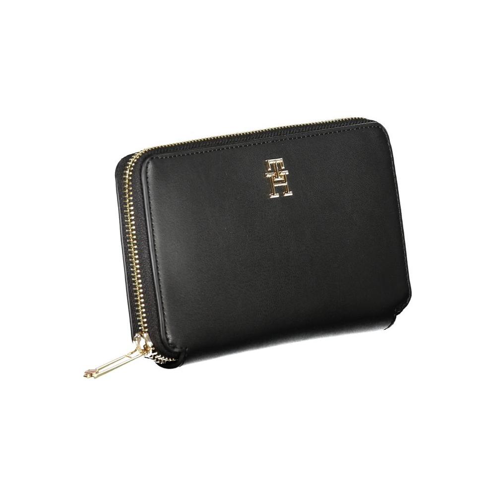 Tommy Hilfiger black polyethylene wallet with 4 compartments, coin purse, card slots, and zipper closure featuring logo.