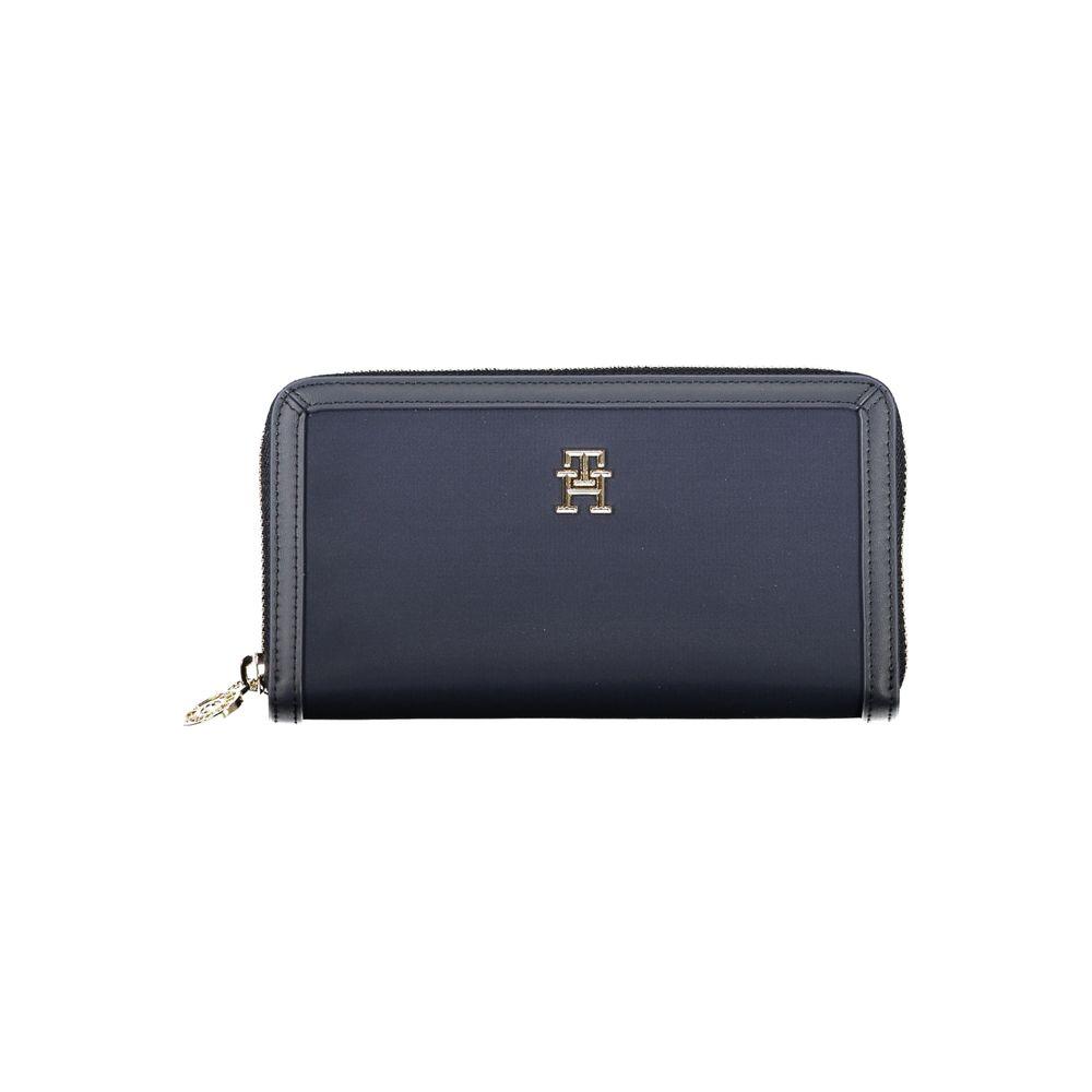 Tommy Hilfiger blue wallet with zip closure, featuring logo, made from recycled polyester, with multiple compartments for cards and coins.