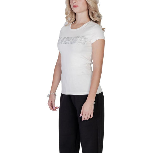 Woman wearing Guess Active cream cotton t-shirt with embossed logo, short sleeves, paired with black pants; perfect for casual outings.